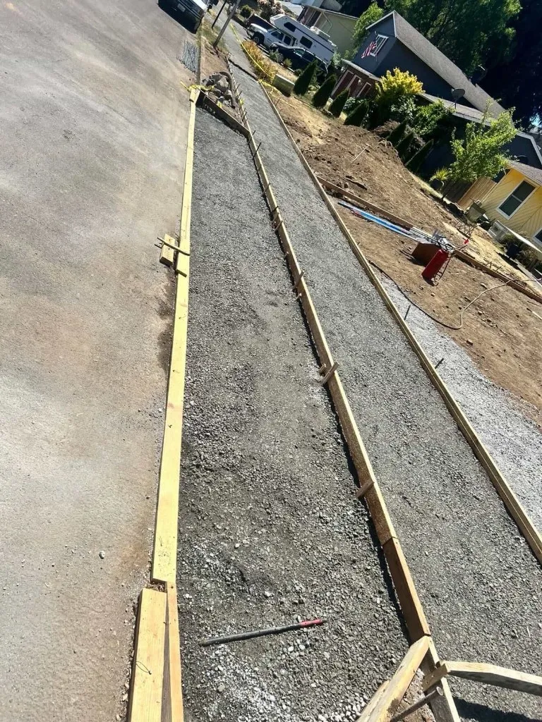 Before: area prepared with gravel sub-base and form-work for new driveway and sidewalk